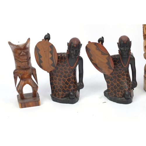 519 - Seven carved wood sculptures including Totem Poles and African figures, the largest 74cm high