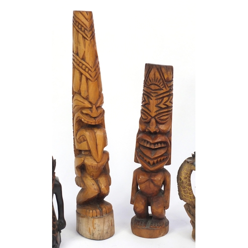 519 - Seven carved wood sculptures including Totem Poles and African figures, the largest 74cm high