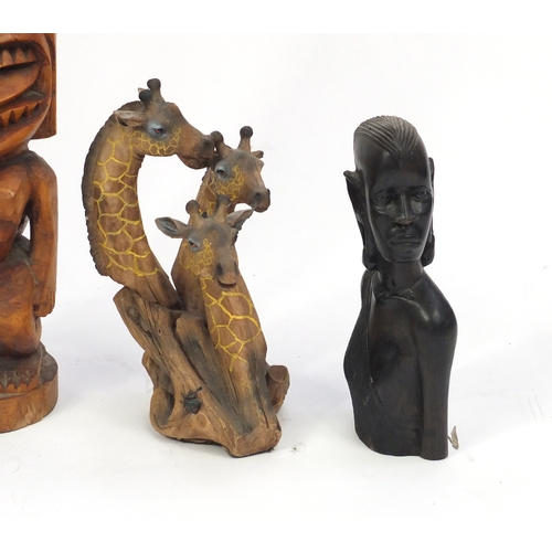 519 - Seven carved wood sculptures including Totem Poles and African figures, the largest 74cm high