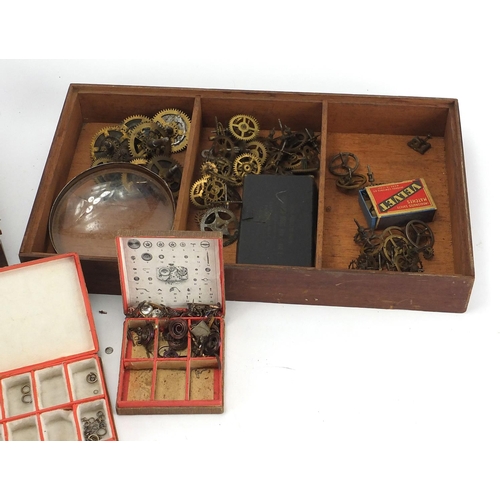 216 - Group of watch makers parts, housed in two glazed display cases, each case 36cm wide