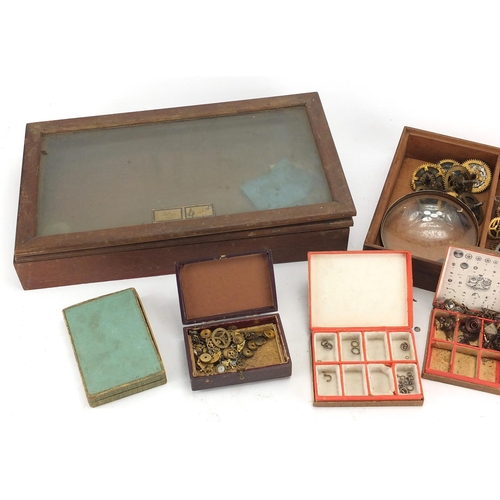 216 - Group of watch makers parts, housed in two glazed display cases, each case 36cm wide