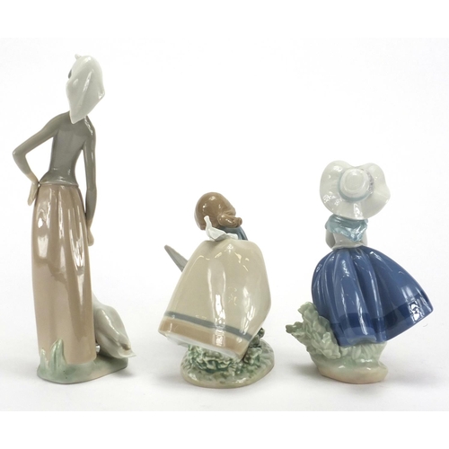 2283 - Three Lladro figurines including a girl with geese and a young girl holding a basket of flowers, the... 