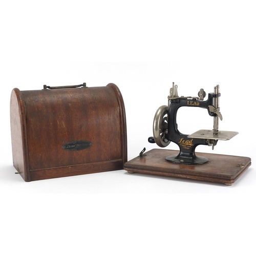 243 - Vintage Lead miniature sewing machine with oak case