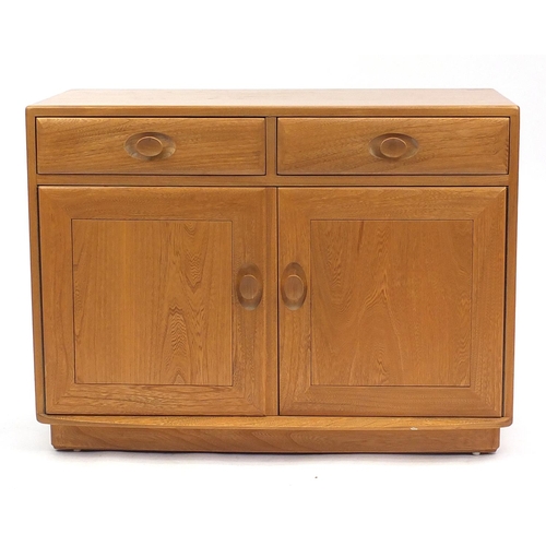 2008 - Ercol light elm side cabinet fitted with two drawers above a pair of cupboard doors, enclosing an ad... 