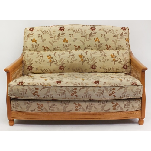 2013 - Ercol light elm bergere two seater settee with floral cushions, 95cm H x 137cm W x 104cm D