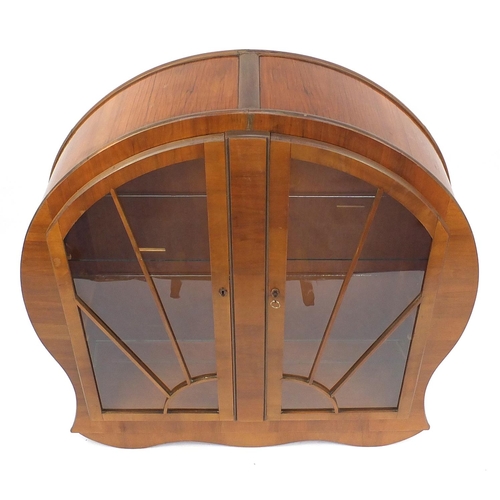 2001 - Art Deco walnut display cabinet fitted with a pair of sunburst glazed doors enclosing two glass shel... 