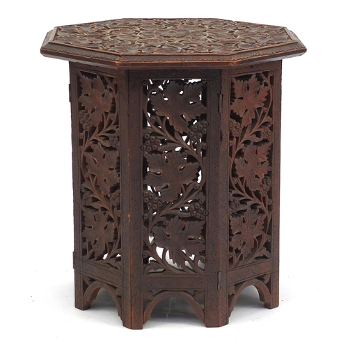 2039 - Octagonal oak occasional table profusely carved and pierced with foliage and berries, 40cm H x 39cm ... 