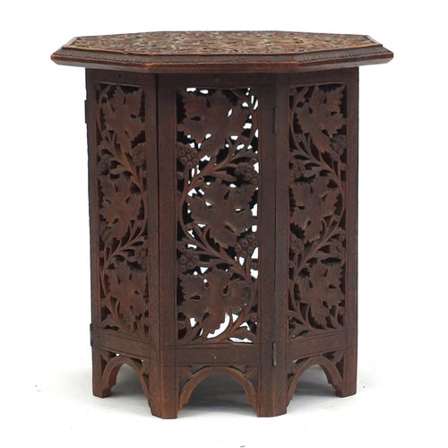 2039 - Octagonal oak occasional table profusely carved and pierced with foliage and berries, 40cm H x 39cm ... 