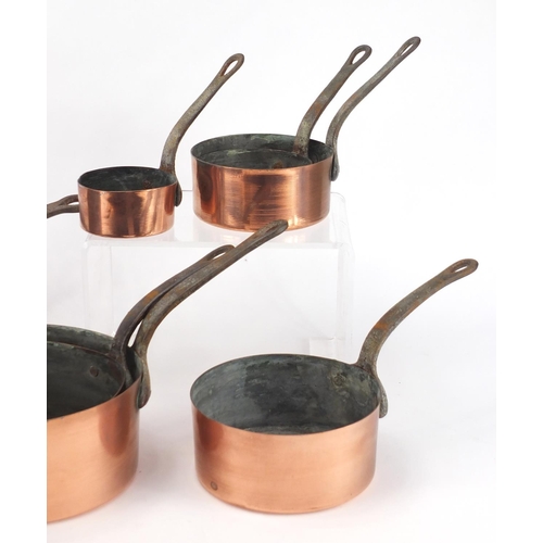 2174 - Graduated set of eight cast iron and copper saucepans, the largest 44cm in length