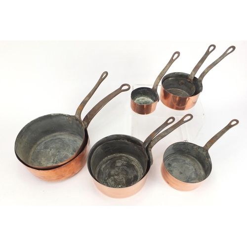 2174 - Graduated set of eight cast iron and copper saucepans, the largest 44cm in length