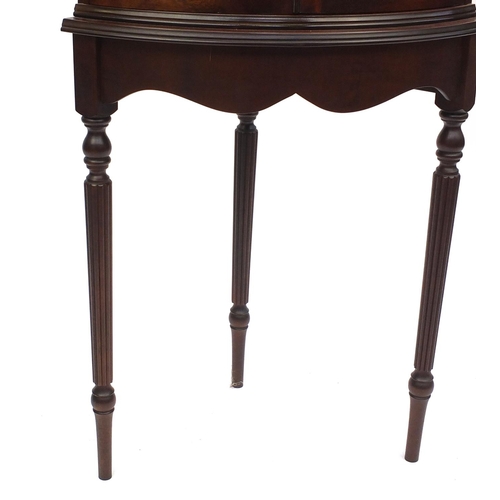 2028 - Mahogany bow fronted standing corner cabinet, raised on tapering fluted legs, 165cm high