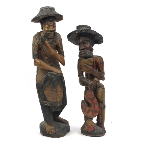 133 - Two large wood carvings both of African men, the largest 103cm high