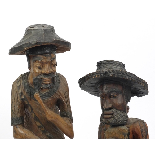 133 - Two large wood carvings both of African men, the largest 103cm high