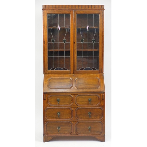 4 - Oak Arts & Crafts bureau bookcase fitted with a pair of leaded glass doors above a fall, with fitted... 