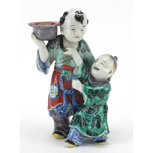 642 - Chinese porcelain figural candlestick, modelled as a father and child, hand painted in the famille v... 