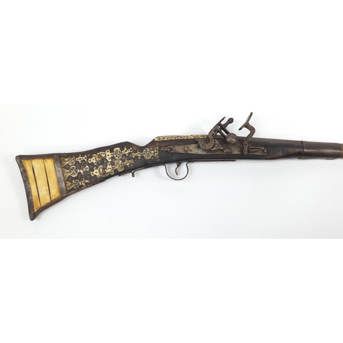 583 - Indian flint lock rifle with bone inlay and a similar pistol, the largest 160cm in length