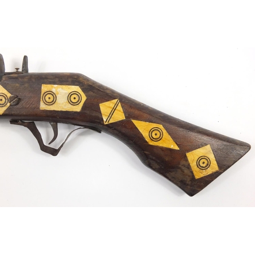 583 - Indian flint lock rifle with bone inlay and a similar pistol, the largest 160cm in length