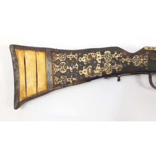 583 - Indian flint lock rifle with bone inlay and a similar pistol, the largest 160cm in length