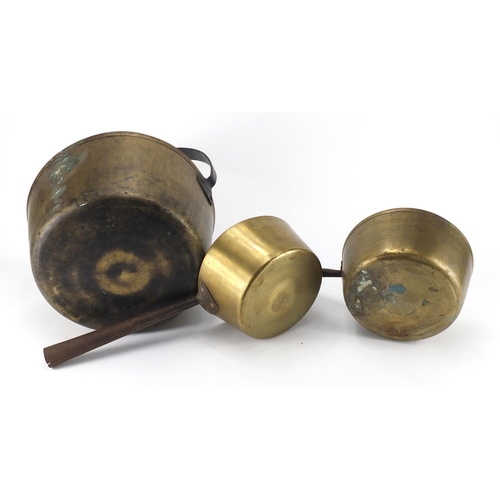 2045 - Brass cooking pan and two saucepans with cast iron handles, the largest 38cm high