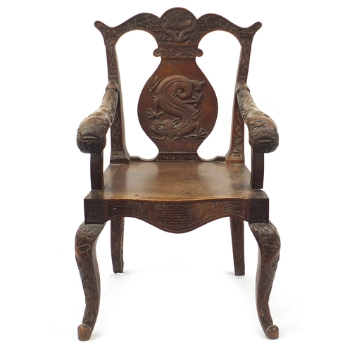 2007 - Chinese hardwood elbow chair profusely carved with dragons, 99cm high