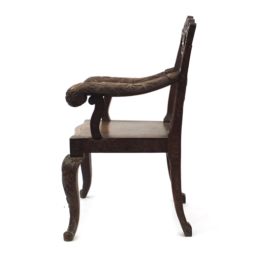 2007 - Chinese hardwood elbow chair profusely carved with dragons, 99cm high