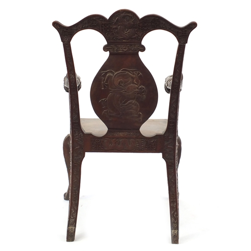 2007 - Chinese hardwood elbow chair profusely carved with dragons, 99cm high