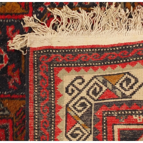 2028 - Rectangular Persian carpet runner having an all over geometric design onto a red ground, 330cm x 78c... 