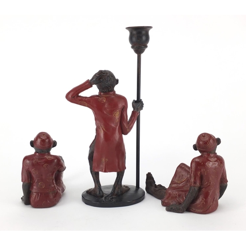 208 - Three monkey's in Oriental dress, one holding a candle holder