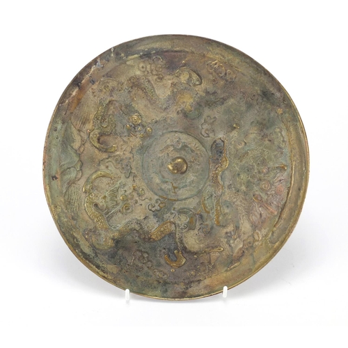 672 - Chinese brass panel, cast with dragons and script, 24.5cm in diameter