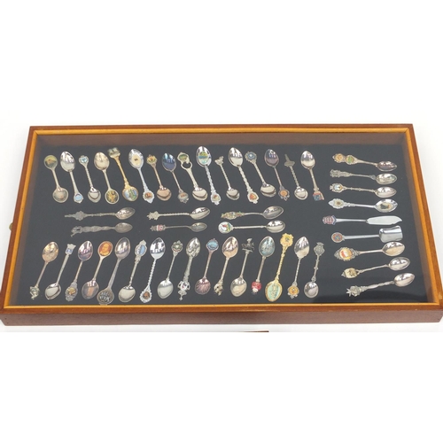 717 - Large collection of souvenir teaspoons, housed in two glazed display cases