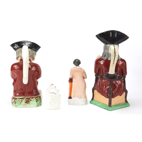 184 - Two Staffordshire figures and two Toby jugs, the largest 28cm high