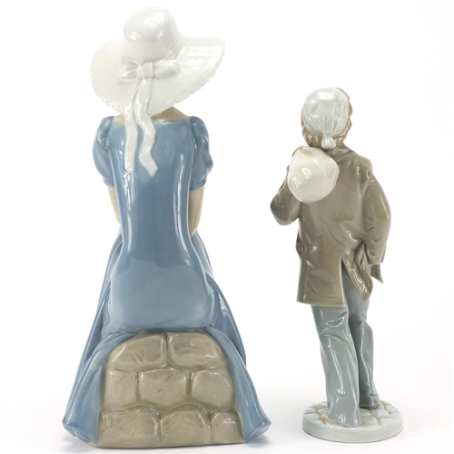 140 - Nao figurine of a girl and a Nao figure of a boy carrying a sack, the largest 28cm high