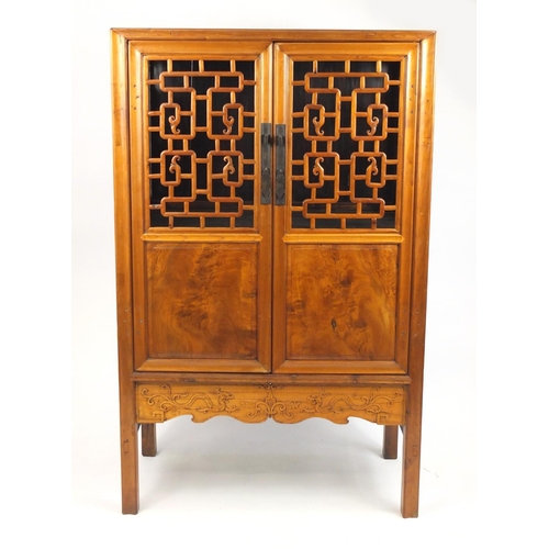 2016 - Oriental hardwood cabinet fitted with fretwork doors, enclosing two open shelves and drawers, 167cm ... 