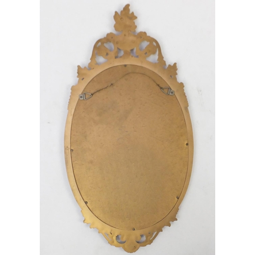 10 - Oval gilt framed mirror with urn finial, 78cm x 41cm