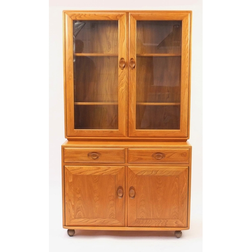 2010 - Ercol light elm wall unit fitted with a pair of glazed doors above a pair of cupboard doors and draw... 