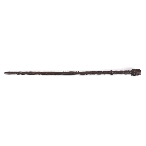 179 - Swiss black forest walking stick with figural carved  pommel, the shaft carved with berries and foli... 