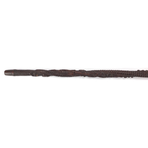 179 - Swiss black forest walking stick with figural carved  pommel, the shaft carved with berries and foli... 