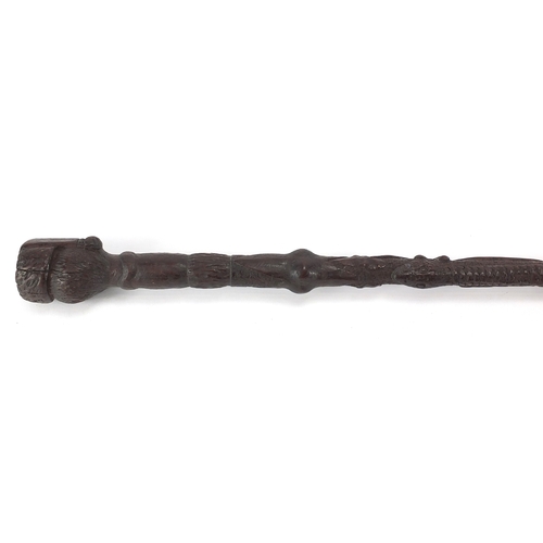 179 - Swiss black forest walking stick with figural carved  pommel, the shaft carved with berries and foli... 