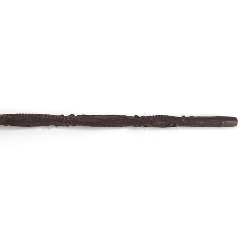 179 - Swiss black forest walking stick with figural carved  pommel, the shaft carved with berries and foli... 