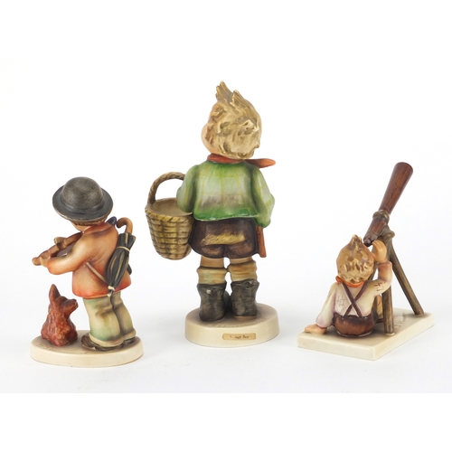 574 - Three Hummel/Goebel figures to include boy with a basket and boy playing a violin with a dog