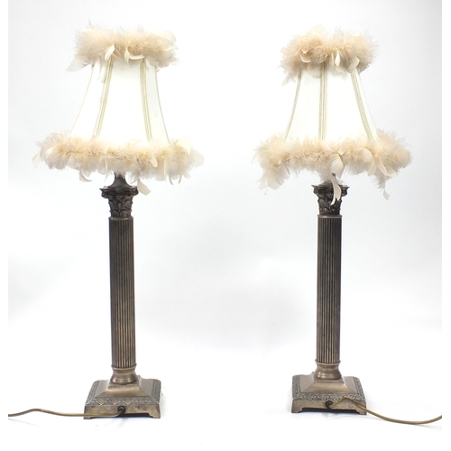 673 - Pair of silvered Corinthian column table lamps, each with silk lined feather shades, each 77cm high