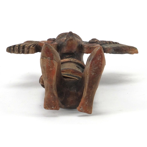 762 - Peruvian hand painted terracotta flute in the form of a kneeling man, 24.5cm in length