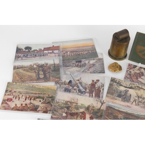 898 - Military interest items including postcards, a trench art lighter and Royal Engineers cap badge