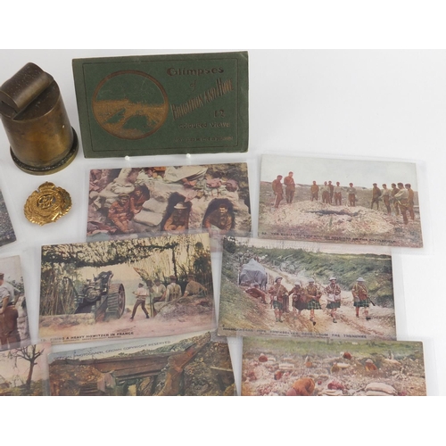 898 - Military interest items including postcards, a trench art lighter and Royal Engineers cap badge