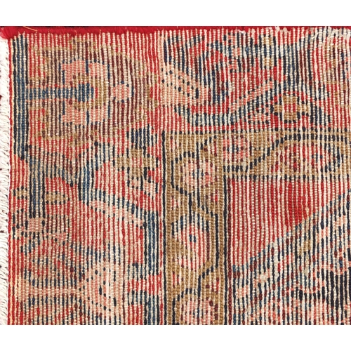 107 - Rectangular Hamadan rug having an all over stylised floral design within two borders onto a red grou... 