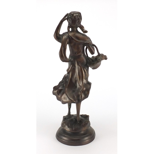 138 - Bronze figure of a young girl carrying a basket of fruit, 43cm high