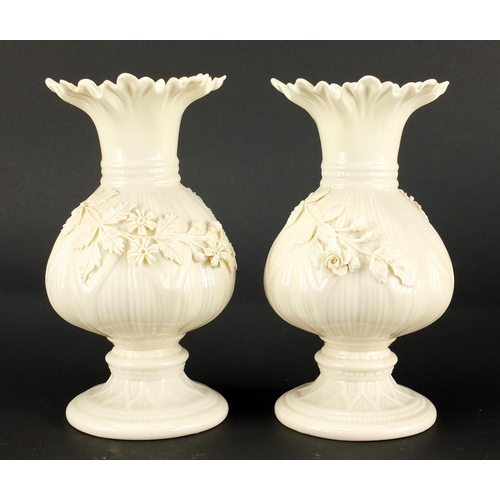 149 - Pair of Belleek porcelain vases, relief decorated with flowers, 20cm high