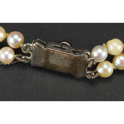 355 - Two string cultured pearl necklace, with unmarked silver clasp, housed in a S. L. Simmons tooled lea... 