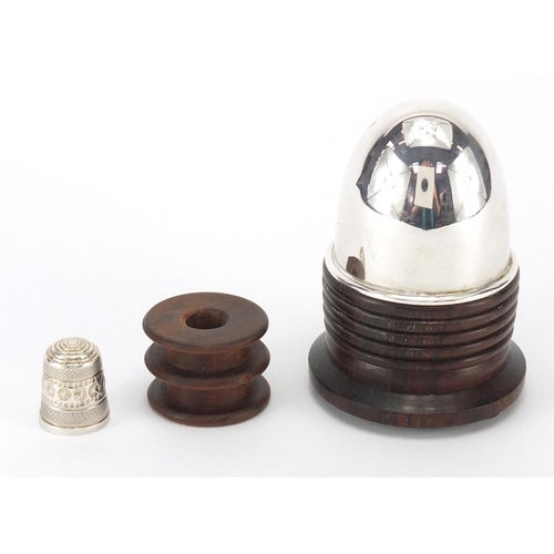 379 - Sewing interest silver topped Lignum vitae cotton reel stand, with thimble, Birmingham 1989, 8cm hig... 