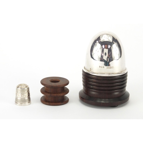 379 - Sewing interest silver topped Lignum vitae cotton reel stand, with thimble, Birmingham 1989, 8cm hig... 